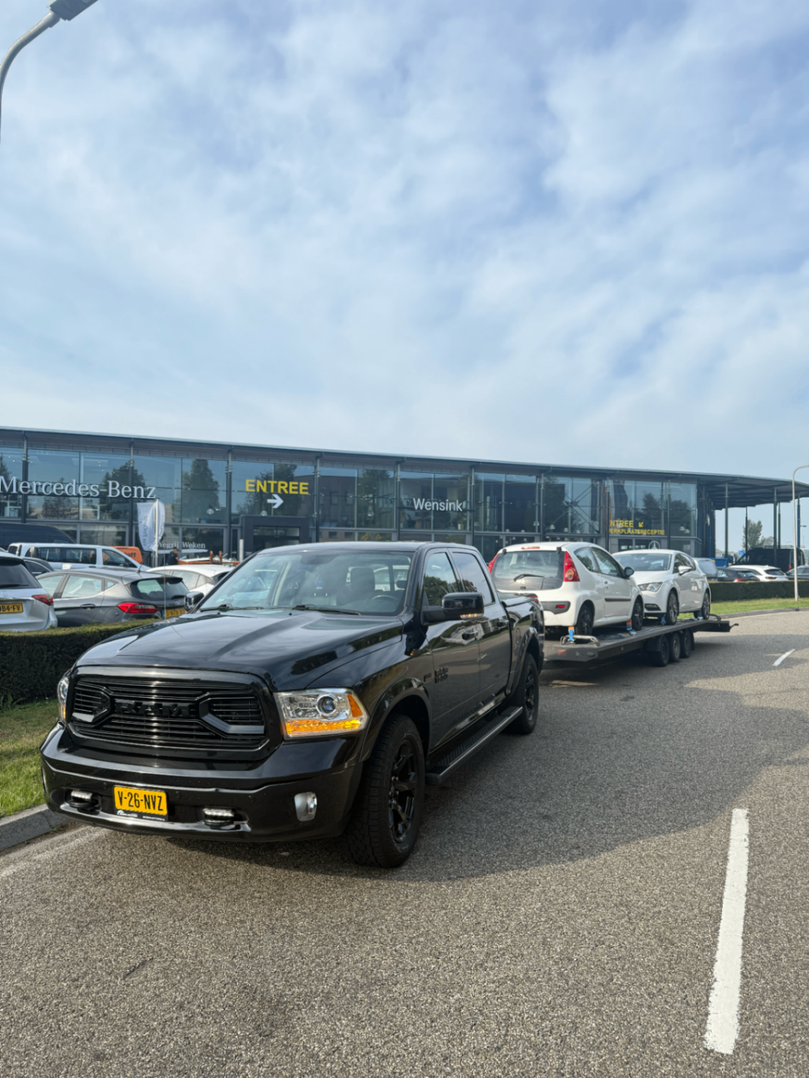 Dodge RAM met meerdere auto's bij een autobedrijf