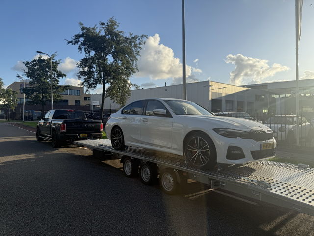 Witte BMW sedan op de autotransporter